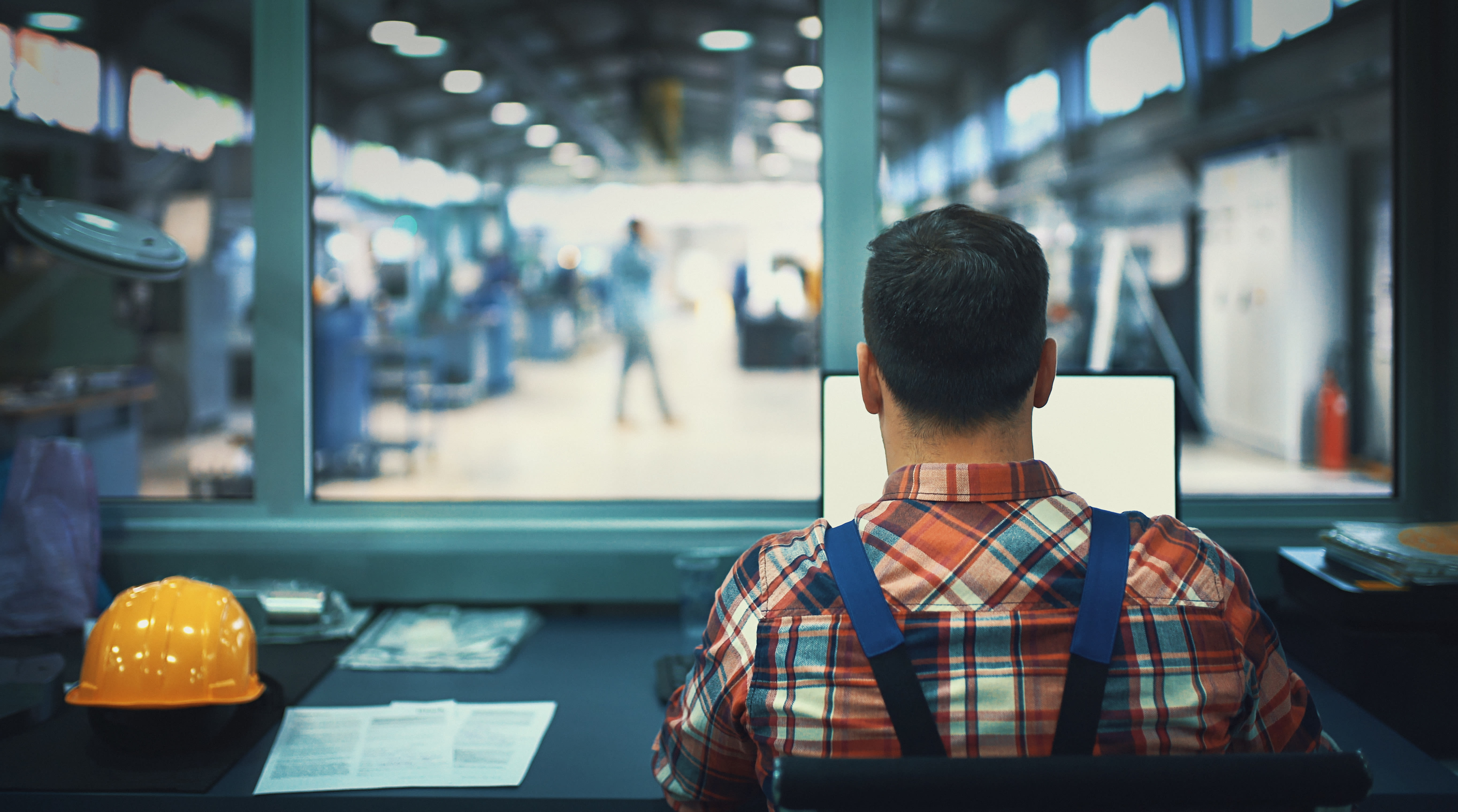 Image of a man on his laptop inside warehouse.